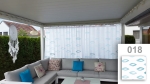 Maßgefertigter Gardinenstore mit blauem geometrischem Muster, auf einer Terrasse über einem grauen Ecksofa aufgehängt.