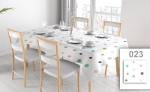 Reclame tafelkleed op maat met gekleurde stippen op een witte eettafel met vier stoelen en elegant servies.