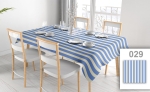 Reclamekleed met blauw-witte strepen op een gedekte tafel in een lichte eetkamer met houten stoelen.