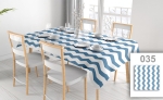 Reclame tafelkleed met blauw-wit zigzagpatroon op een rechthoekige tafel met wit servies in een lichte eetkamer.