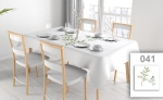 Toalha de mesa publicitária branca com impressão de folhas verdes numa mesa retangular com loiça numa sala de jantar iluminada.